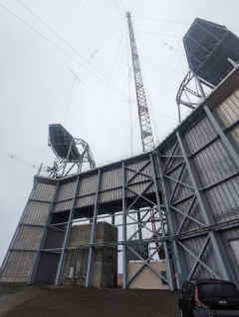 Building with hooded gantries and a tall mast