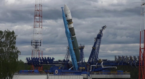 Soyuz-2 rocket on its transporter-erector at a launch pad under a cloudy sky