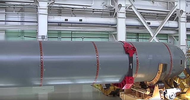 Mid-section of the Poseidon vehicle with red bands and a red cradle clamp in a factory hall