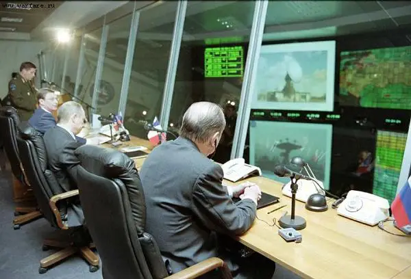 Officials at a command desk overlooking radar and map monitors